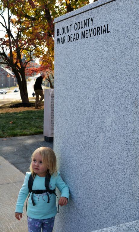 Toddler girl stands beside Blount County War Dead Memorial stone